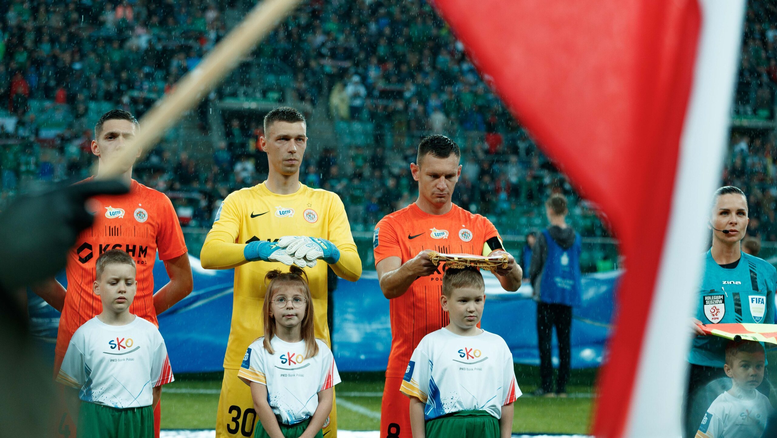 2025.05.03 Wroclaw
Pilka nozna PKO Ekstraklasa sezon 2024/2025
Slask Wroclaw - KGHM Zaglebie Lubin
N/z Dominik Hladun na hymnie przed meczem chroni rekawicami dziewczynke z eskorty przed deszczem Damian Dabrwoski proporczyk nad glowa chlopca
Foto Tomasz Folta / PressFocus